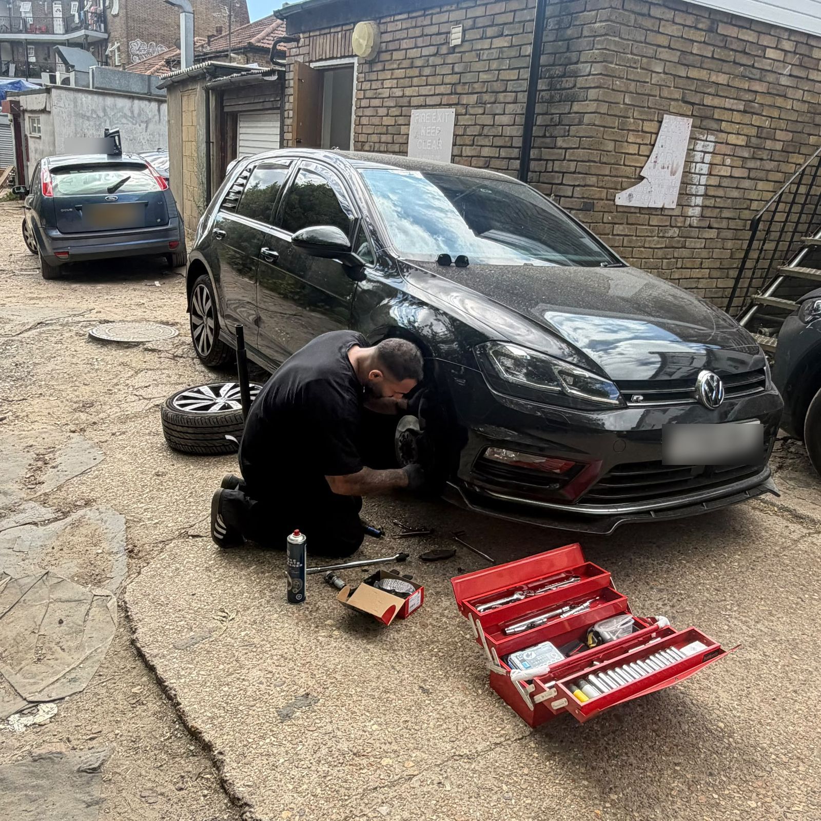 MaxFix Auto technician replacing a front brake assembly on a Volkswagen Golf